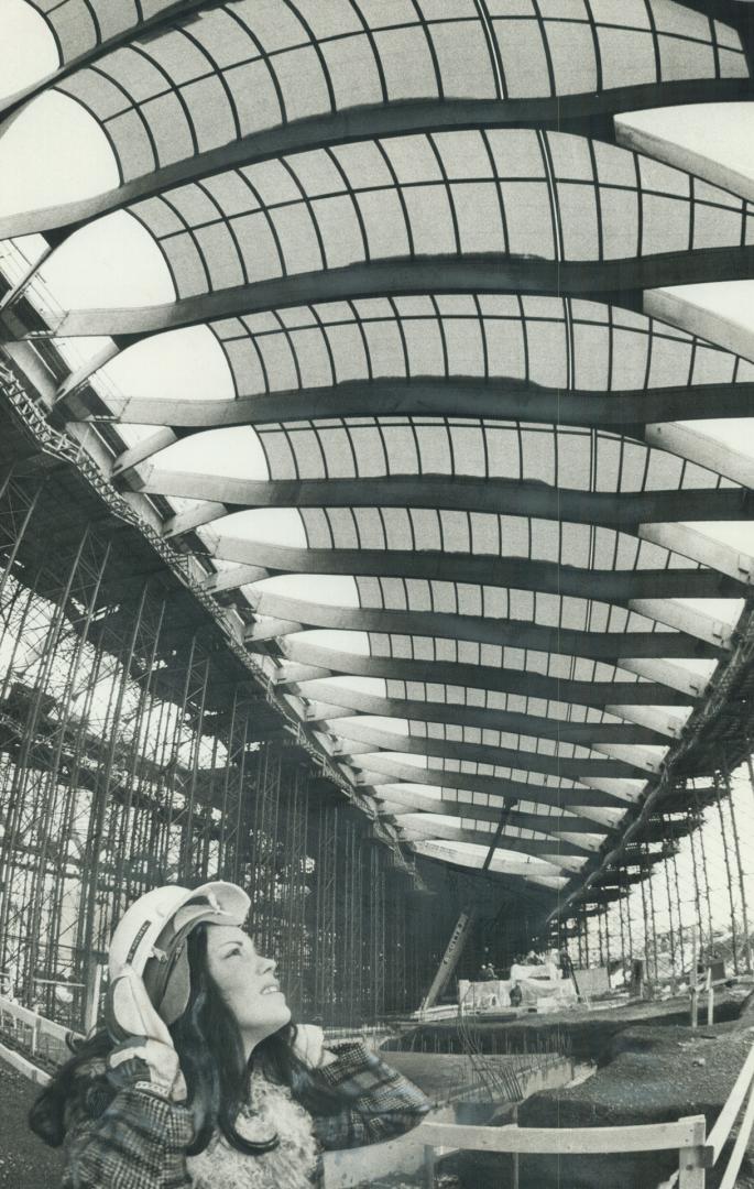 High above Olympics hostess Carole Gauthier is the translucent roof of the velodrome
