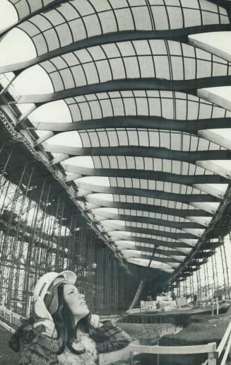 High above Olympics hostess Carole Gauthier is the translucent roof of the velodrome