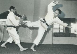 Weingust, 42, uses his foot to break piece of wood held by karate instructor Kyong Lee