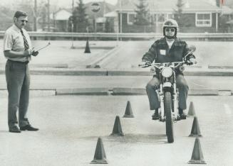 Driver examiner Fred Hanneman checks John King, as he manoeuvers his motorcycles around Department of Transportation and Communications test course at(...)