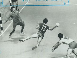 Soviets sweep team handball. Tripped by Romanian, Russian handball player takes involuntarily to air and aims ball at far side of net