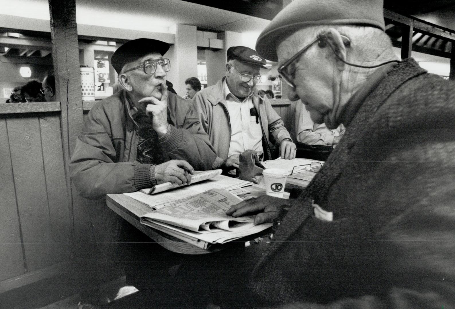 Quick studies: Three fans at Greenwood mull over their picks during yesteday's big day of Breeders' Cup racing seen via television from Kentuckey