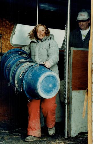 Kim Switzer (above) has her hands full with essential equipment, feed barrels