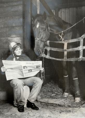 Jockey and horse look over the day's entries during a quiet moment at track's stable area
