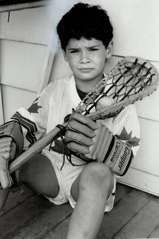 Caught in the middle: Raymond Lippett, 8, wants to play lacrosse in Mimico this summer, but he can't get a release from the Eclipse Lacrosse Association where he's played since he was 5