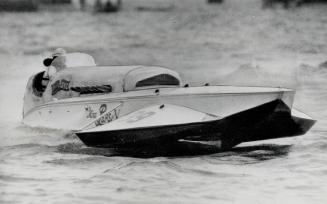 Miss Peps V., driven by Danny Foster for a Detroit sponsor, is shown speeding along in wining fashion in the International Gold cup races. The course (...)