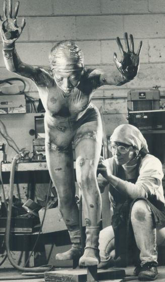 Lois Hannal Elliot does the final work at a Georgetown foundry on a bronze statue of a young athlete