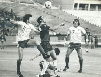 Heads up! New York Cosmos' Giorgio Chinaglia is set to head ball with Blizzard's Willie McVie (5) and Cliff Calvert (10) closing in. Cosmos won, 1-0, (...)