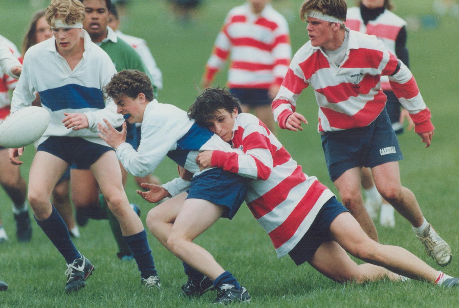 Forcing the play, A Markham player gives up the ball after getting grabbed by a Brother Andre tackler during yesterday's York Region midget rugby fina(...)