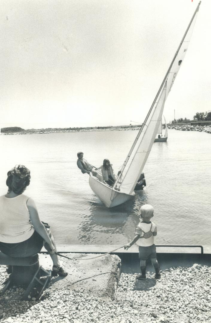 See the pretty sailboats, Lorraine Urquhart holds her son James, 22 months, safely on a leash while they watch sailboats dancing in Port Credit harbor(...)