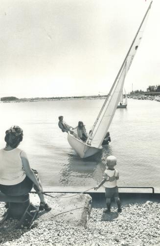 See the pretty sailboats, Lorraine Urquhart holds her son James, 22 months, safely on a leash while they watch sailboats dancing in Port Credit harbor(...)