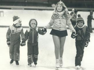 Juli-ann Griffin helps three of her young students across Centennial arena ice between her own practice spins