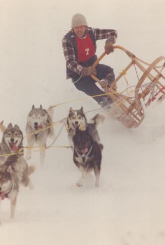 With their sled almost airborne, hard-driving huskies haul Doug McNeil of Guelph to victory in the 9