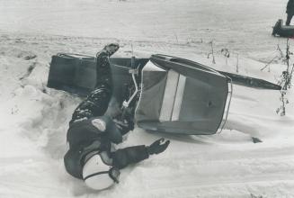 It's a hard way to land when you tip a snow-mobile at high speed, as driver Bill Sakeris shows in this deliberate spill