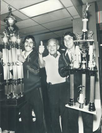 Paul Roe (left) displays second-place trophy and Gerry Gray holds most-gentlemanly-team award, John McMahon gives high sign