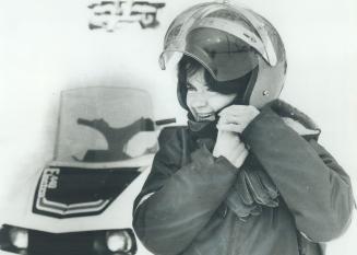 Snowmobiler Glenna Sears of Creemore buckles on her helmet before setting out at a snowmobile resort
