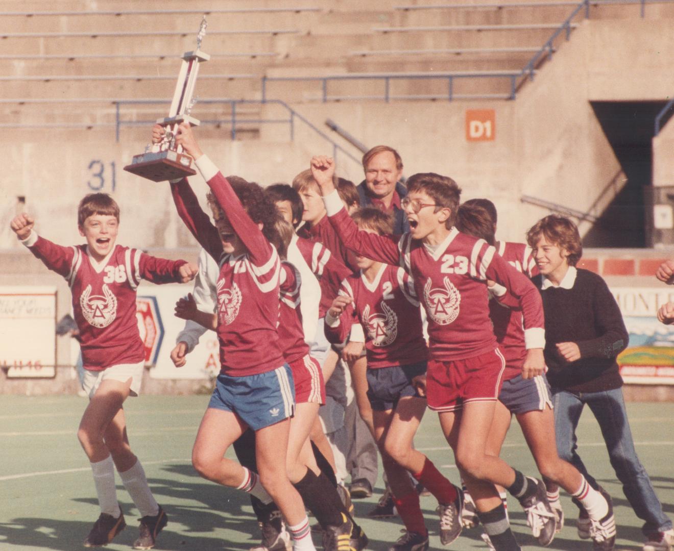 Hey, we're the champs!, With the championship trophy in his grasp, a member of the Annette public school soccer team leads his mates on victory lap at(...)