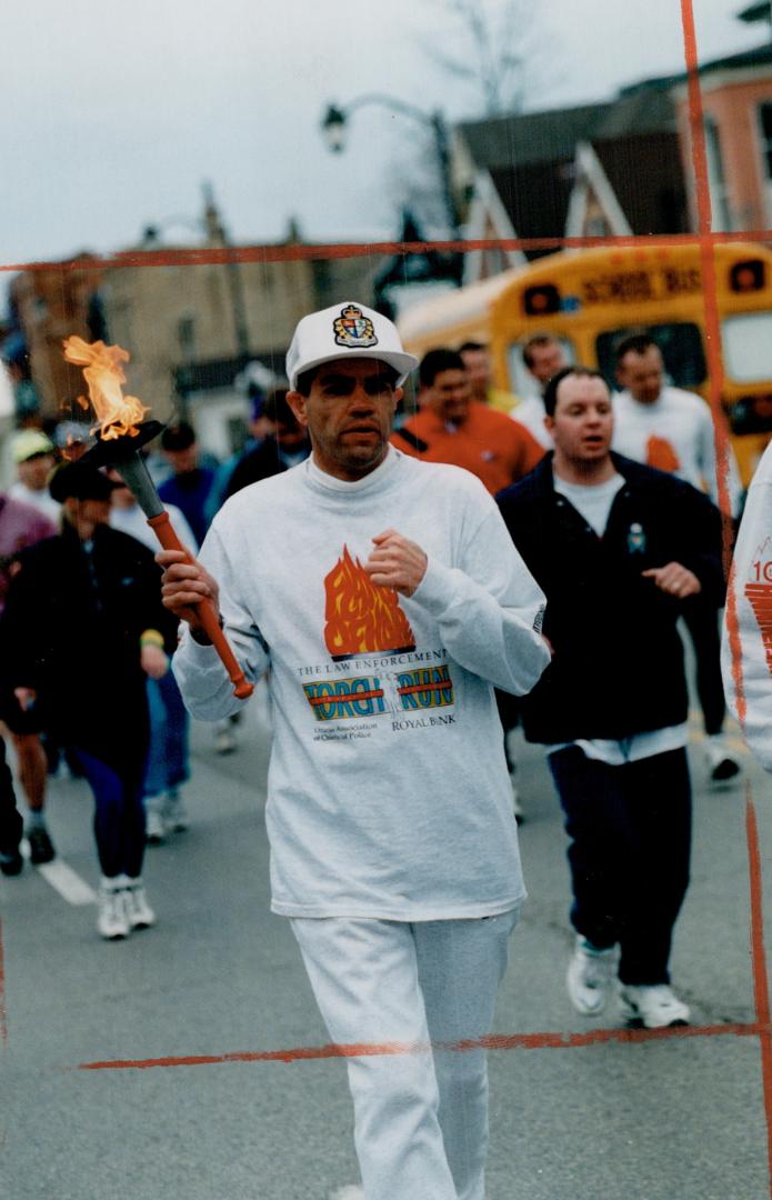 Carrying the torch, Alec Kinng, a swimmer, carries the Special Olympics torch on the Main St