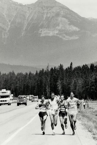 On the first leg of the Jasper-Banff relay race, coach Don Doc Lyons offers a watersoaked sponge and Gatorade to runner Marjory Stewart. A Toronto ins(...)