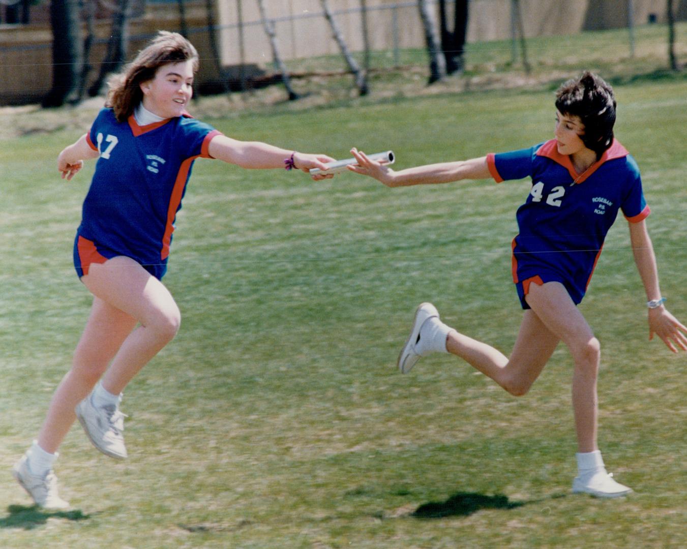 Kerri McLaughlin, left, Passes the baton to Angie Graham, both Grade 7 students at Rosebank public school, during a practice for the Durham track and field finals scheduled for June 8