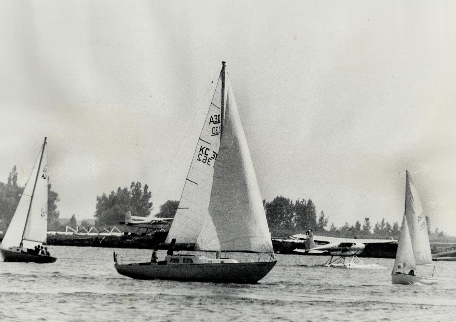Seaplanes form a backdrop for part of the sailing action near Toronto Island during Saturday's Ashbidge's Bay open regatta, part of the Metro Yacht Ra(...)