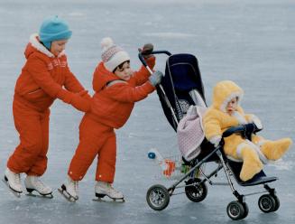 Outta my way, I'm strolling on the pond, Two-sister power -- from Laura, 4, and Jennifer, 3 -- takes 7-month-old Paul for a glide down the ice on the (...)