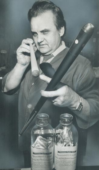 It's first class. Don Stoyanovich of Rack and Cue Billiards checks on customs cue that is being raffled off with proceeds going to the Sportsmen's Corner of The Star Santa Claus Fund