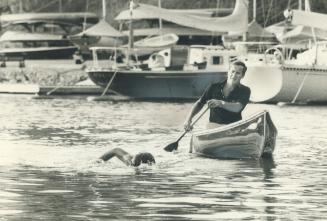 Training to swim Lake Ontario next month, 18-year-old Joe Schnittker of Oakville swims in Oakville harbor under the watchful eyes of his coach, Jim Cl(...)