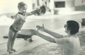 Water babies. Two-year-old Sharon Yonge, in top photo, happily jumps into mother Janice's arms in swimming class at Huron Park swimming pool in Missis(...)