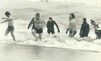 Frolicking in Lake Ontario at Hamilton Polar Bear Club's New Year's Day swim are Brian Atkinson (left), 21, Corky Atkinson, 44, and Don Jones, 25, as divers watch