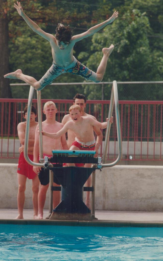 Virgil Marshall, 10, takes a flying leap off the board at Monarch Park pool in the east end yesterday as others line up for the same privilege. Toront(...)
