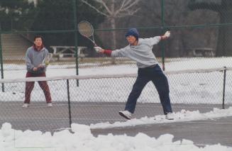 Diehard tennis players Kim in Bok (foreground) and Kiwoong Bae don't let a little snow keep them from the court cleared all winter