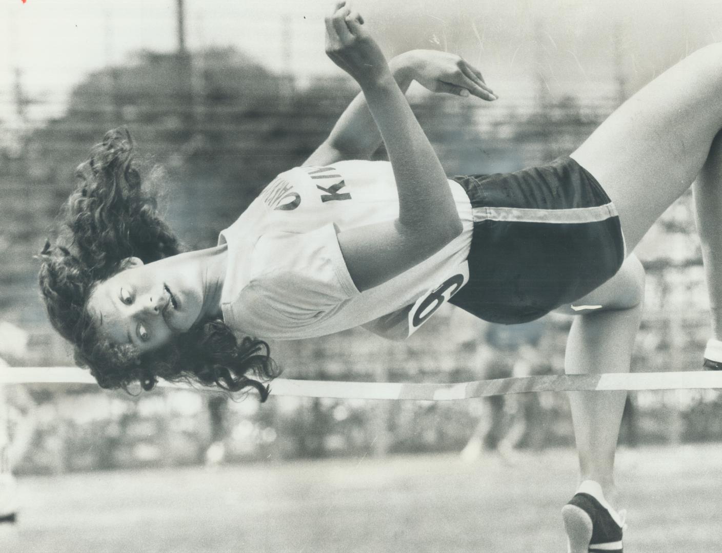 It's a long way down! Janice Brewer of Oakville Kiwanis track club looks towards the ground as she clears bar to win midget girl's high jump event in (...)