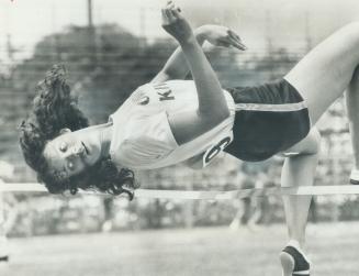 It's a long way down! Janice Brewer of Oakville Kiwanis track club looks towards the ground as she clears bar to win midget girl's high jump event in (...)