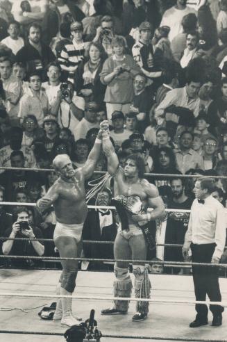 Hald to the champ: A sportsman to the end, Hulk Hogan hoists the hand of the new champ, who clutches the belt attesting he is wrestling's Ultimate Warrior