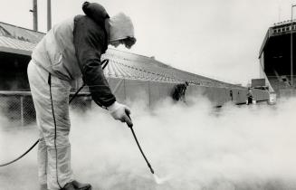 Getting ready: Sam Viera uses steam to blast away dirt on the field at Exhibition Stadium yesterday as the crew makes preparatios for the Jays home opener next Monday against the Yankees