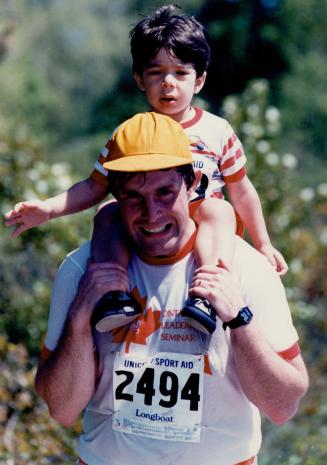 Scott Moulson, left, gives son Matthew, 2 1/2, a taste of the 10-kilometre (six-mile) course, which proved trying for some, right