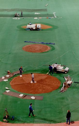 Workers prepare the SkyDome field yesterday for the Blue Jays home opener, at 7