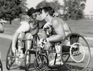One for the road. Ron Robillard, 23, the fastest wheelchair racer in the world, congratulates fiancee Marni Abbot, 22, with a smooch yesterday after h(...)