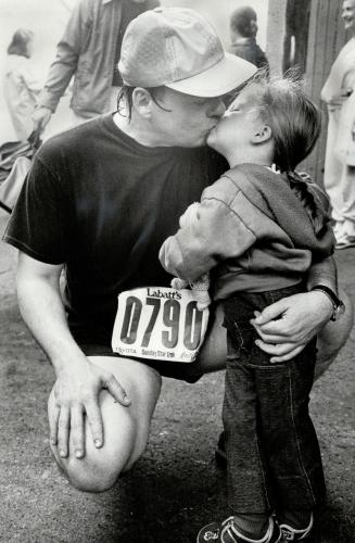 Reward: Ross McLeod, tired and sweat-bedecked, gets kissed for his efforts from his four-year-old daughter, Melanie, at the finishing area in Varsity Stadium