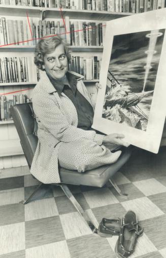 Science fiction writer Judith Merril holds a picture of a space ship in the Spaced-Out Library at 566 Palmerston Ave