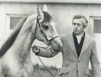Hans Bauer relaxes with one of his five horses at his home near Guelph