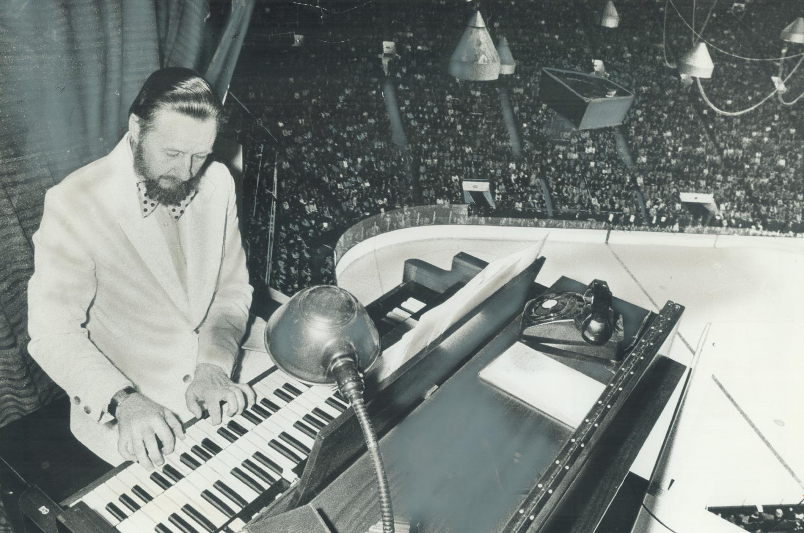 Perched on a pylon 85 feet above the ice surface, Ralph Fraser has a bird's eye view of hockey action in Maple Leaf Gardens where he plays the nationa(...)