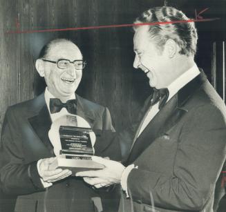Lionel Lester (left) last night was presented the Pioneer of the Year award by Don Watts, president of the Canadian Motion Picture Pioneers