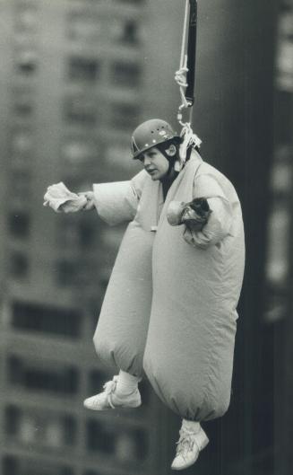 Keeping him in suspension, Comedian Marty Putz spends some time suspended 152 metres (500 feet) above Yonge and Bloor Sts. yesterday. [Incomplete]
