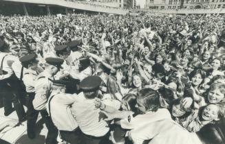 Screaming teenage girls rush police lines at Nathan Phillips Square trying to get to the Bay City Rollers who made two three-minute appearances before(...)