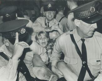 Carried away by the emotion surrounding a Beatles performance, a young girl is taken off by policemen