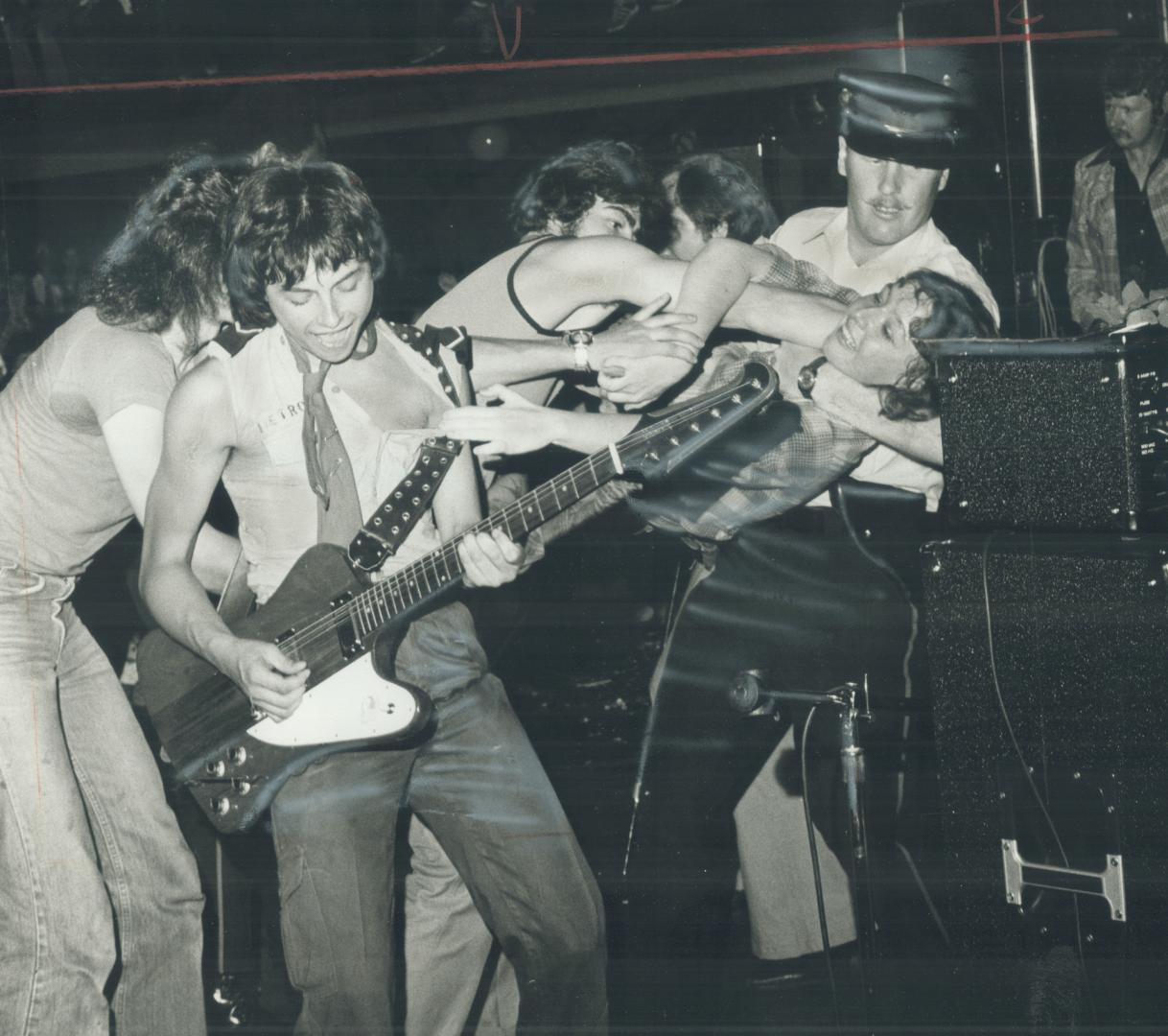 Police had their hands full as they tried to keep frenzied young fans from ex-Bay City Roller guitarist Ian Mitchell (foreground) as he led Rosetta St(...)