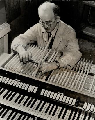 This organ maker is engaged in the operation of putting the action in the console