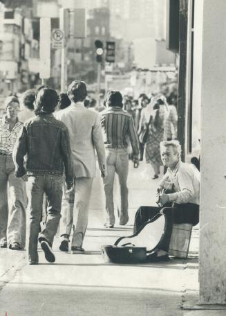 Musicians on Yonge St., like Arthur Payne, 35, above, add a human quality to the street and should be encouraged by the merchants, reader says below, to keep the downtown area vibrant